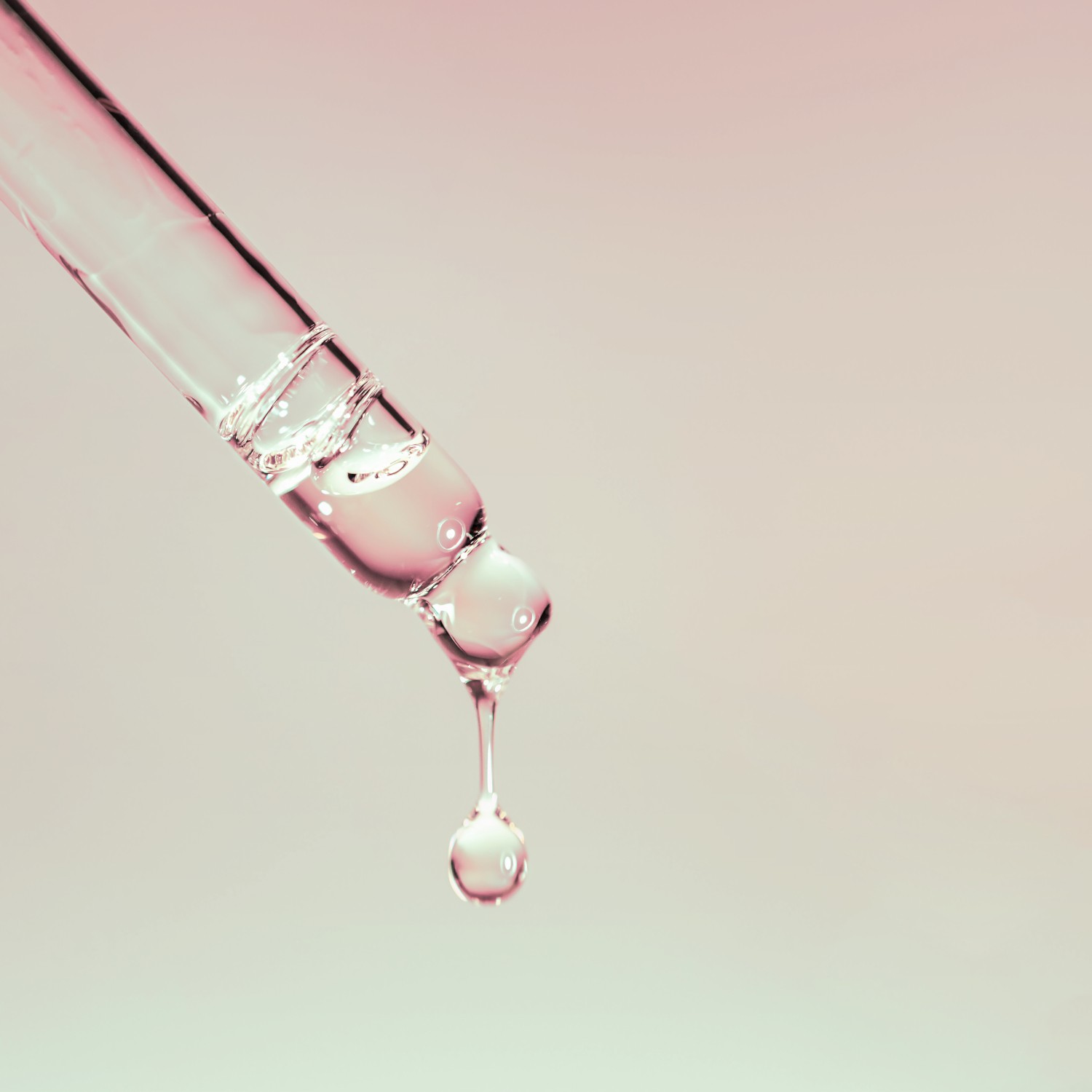 A drop of cosmetic oil falls from the pipette