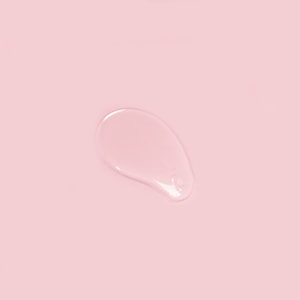 A top-down close-up of a perfectly clear, smooth swatch of thick shower gel base resting gracefully on a solid pastel pink surface.